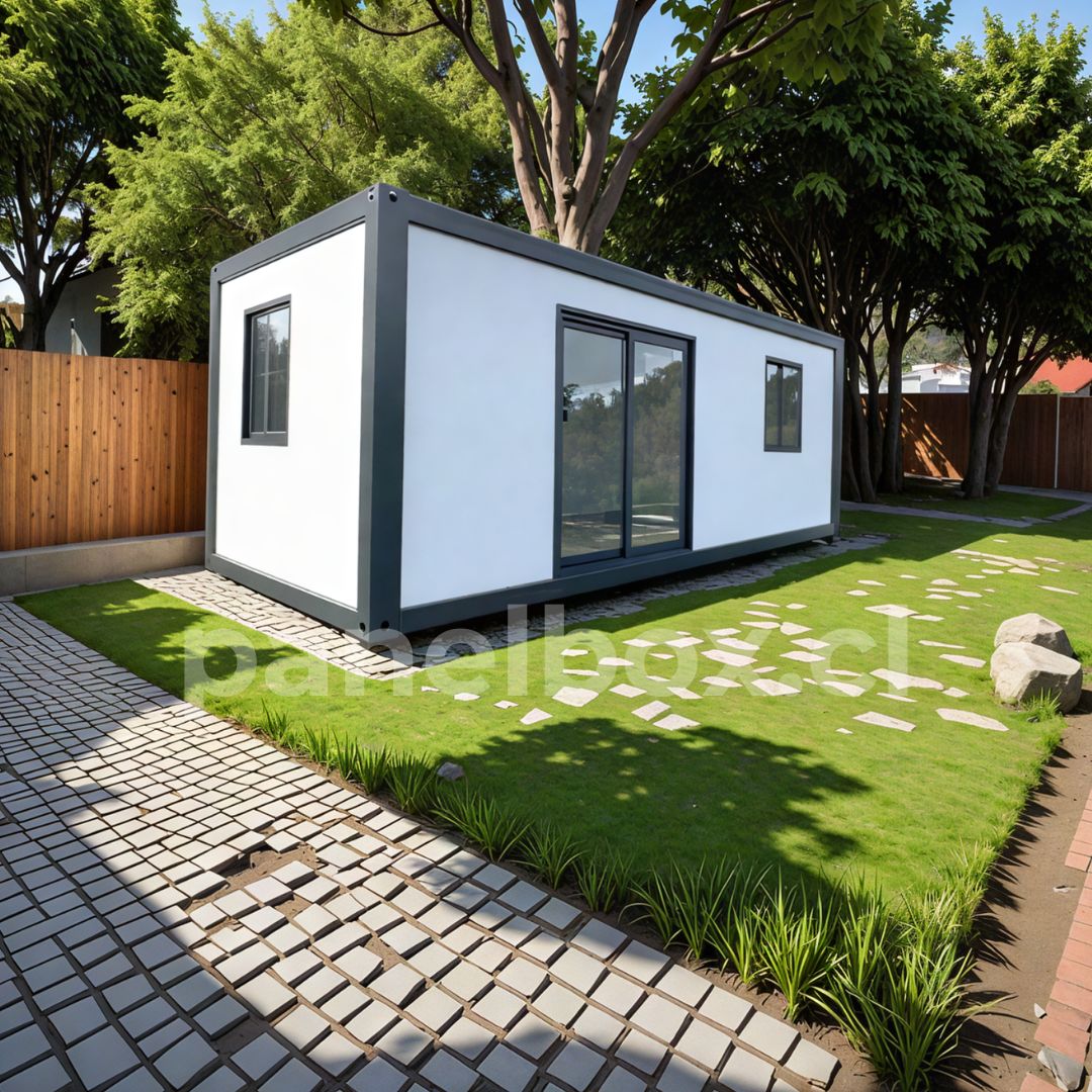  Tiny house modelo básico Mecano de 3 × 7 m, revestimiento negro, en un entorno natural rodeado de árboles y vegetación silvestre.